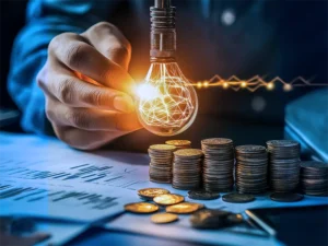 Mão segurando uma lâmpada brilhante conectada a redes de energia digital, com pilhas de moedas ao lado, simbolizando inovação e crescimento financeiro. Poupança familiar com Livil Traxquent Phigra utiliza inteligência artificial para otimizar a gestão de finanças e maximizar os investimentos familiares.